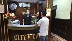 A reception desk with clocks indicating time in London, Cairo, and Tokyo, a certificate of excellence, and a sign instructing to check at 12:00 no. - City View Hotel (Cairo)