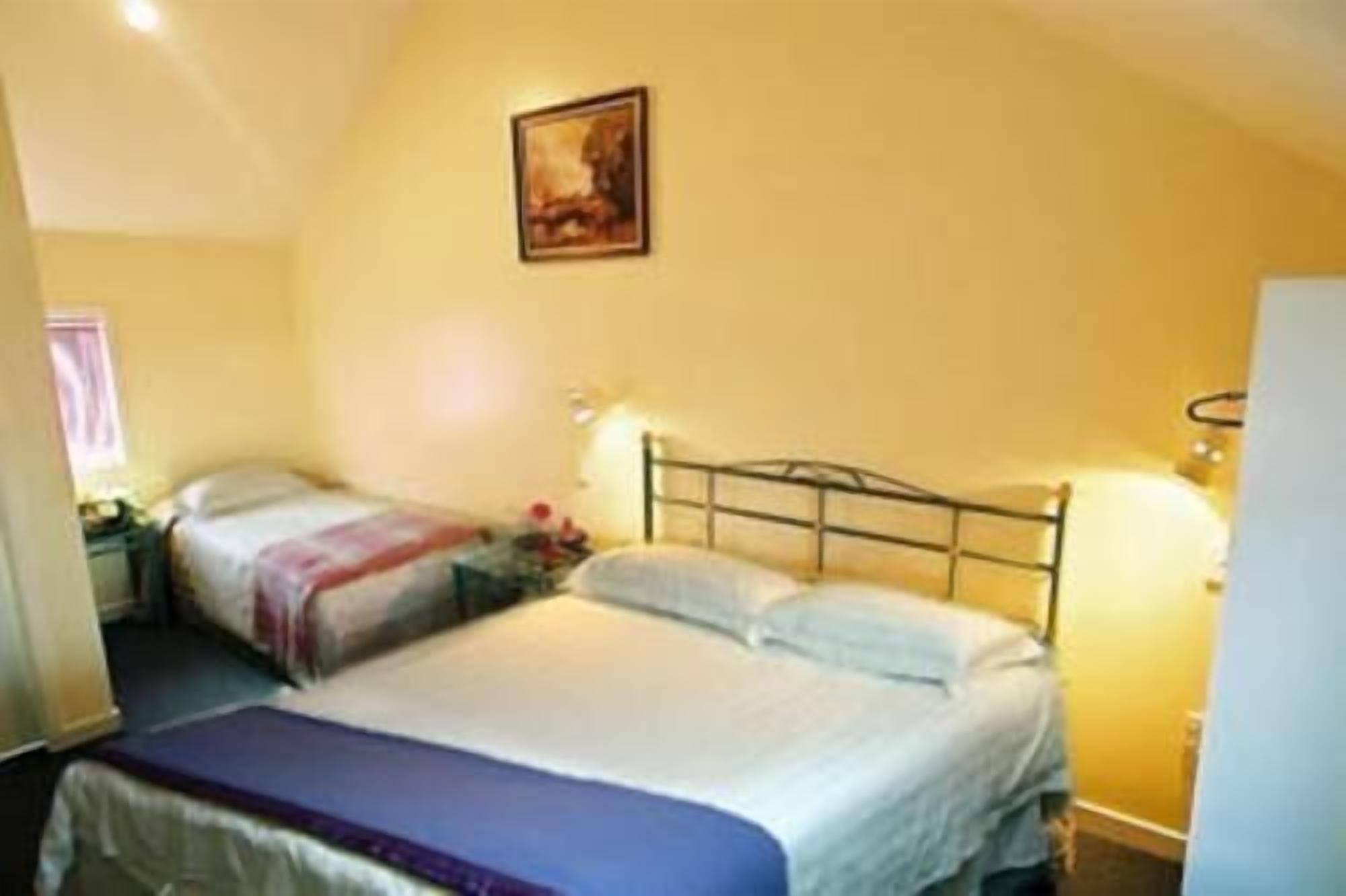 Ein Einzelzimmer mit Bett, Nachttischen und einem Bild an der Wand.