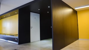 A modern hotel room with a minimalist design, featuring a bed, a door, and a bright yellow accent wall. - Bittar Inn Hotel (Brasília)