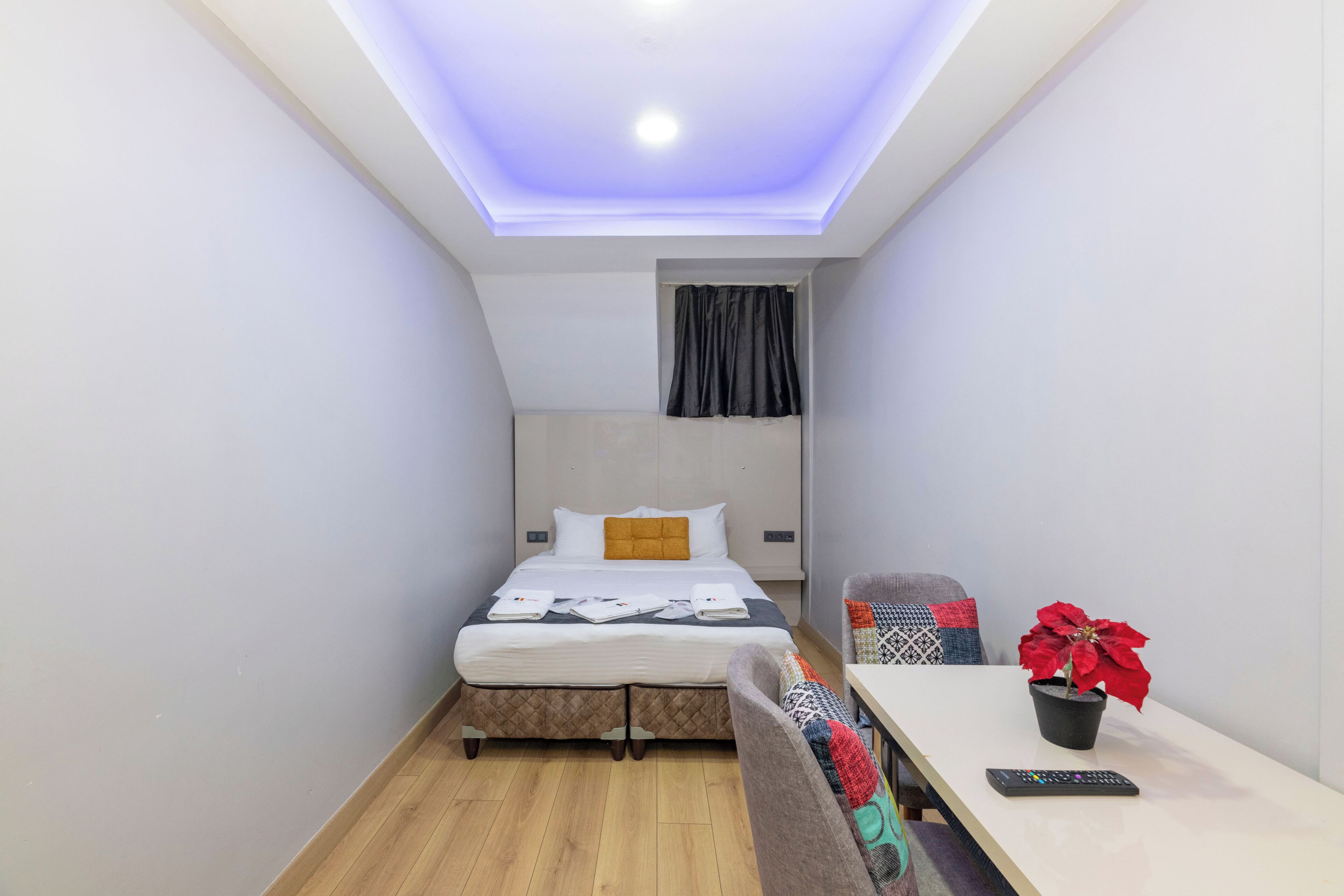 Una habitación pequeña y moderna con una cama, una mesa y una silla.