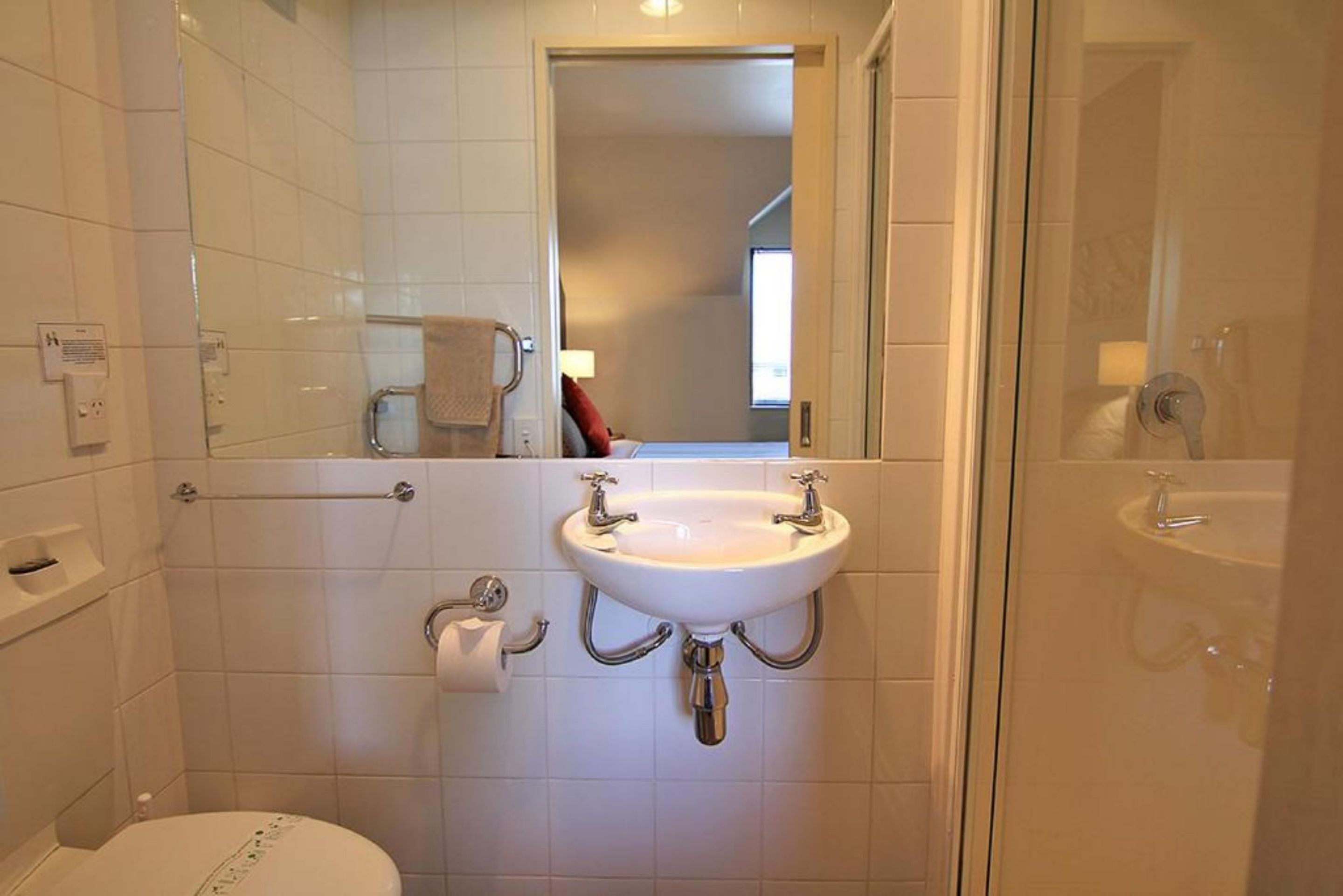 Un baño con un lavamanos blanco, un inodoro y una zona de ducha.