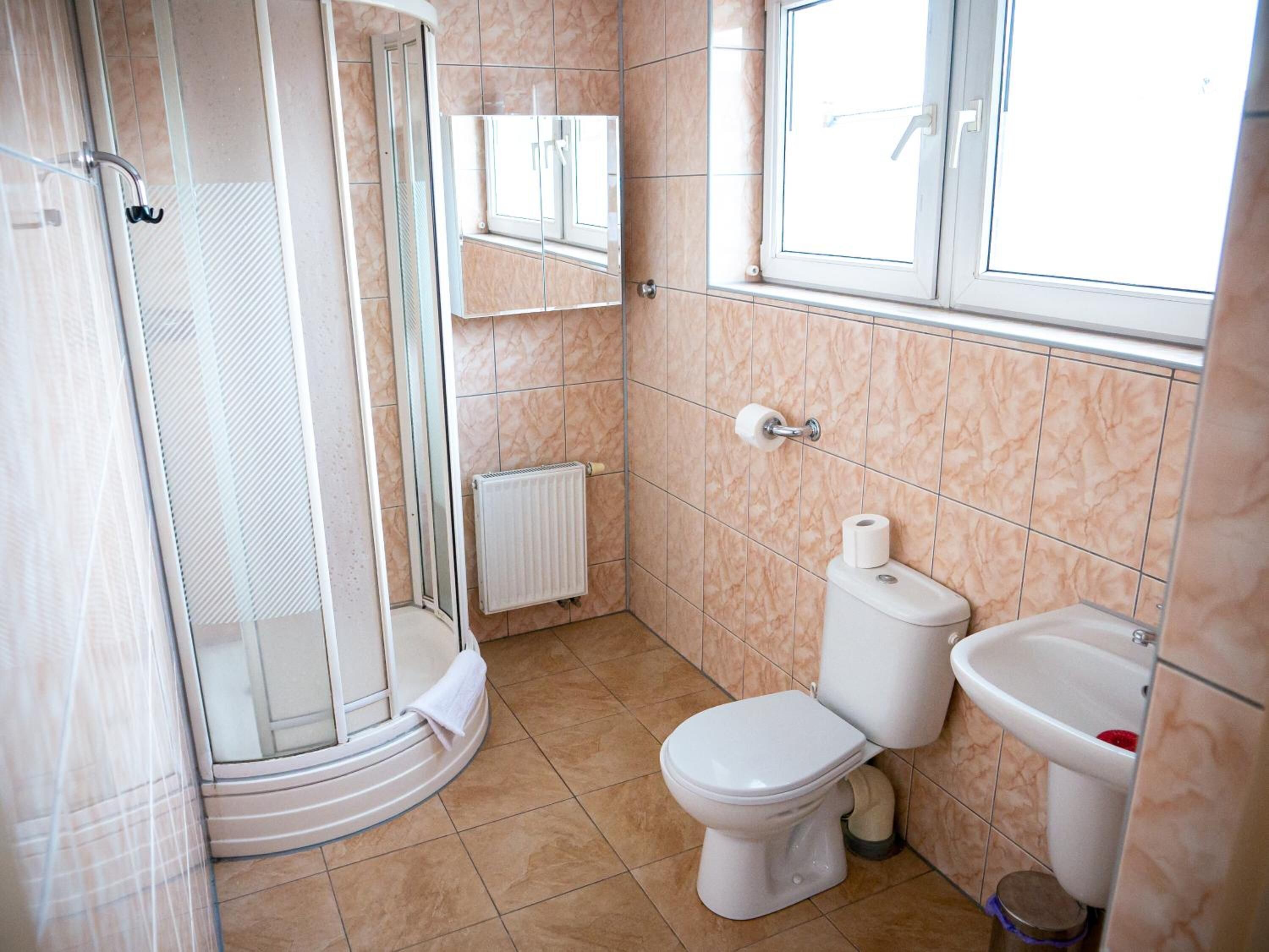 Un baño con ducha, inodoro y lavamanos.