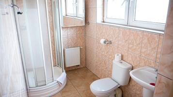 Un baño con ducha, inodoro y lavamanos.