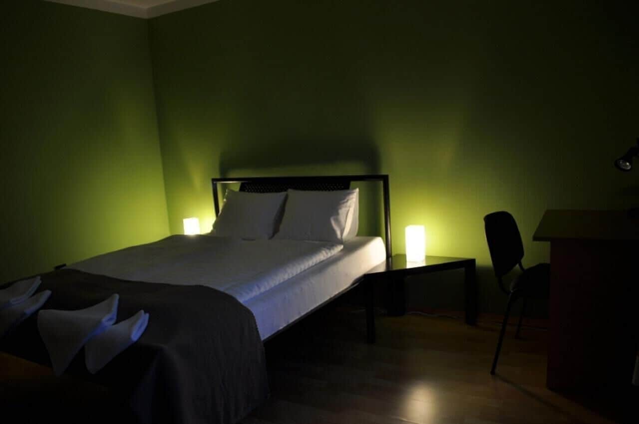 A hotel room with a bed, bedside tables, and a chair.