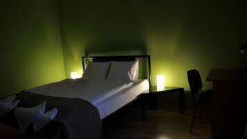 A hotel room with a bed, bedside tables, and a chair.
