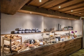 A breakfast buffet with bread, pastries, and condiments. - Hotel Neuwirt (Finkenberg)