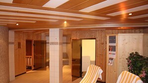 Interior de fusta amb una zona de recepció, una porta que dona a un bany i un suport per tovalloles amb tovalloles.