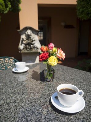 Una mesa con una taza de café y un jarrón de flores.