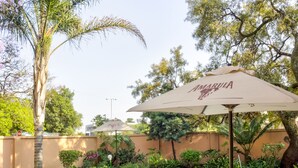A swimming pool with lounge chairs and an umbrella labeled "AMARULA."