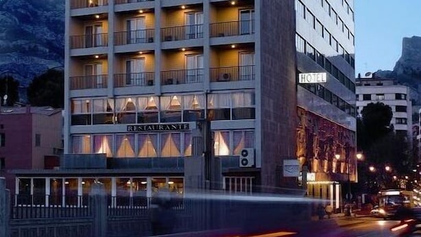 A multi-story hotel with balconies, a restaurant on the ground floor, and a sign indicating it is a hotel. - Hotel Reconquista (Alcoy)