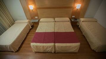 Una habitación con una cama grande, dos mesitas de noche y dos lámparas de pared.