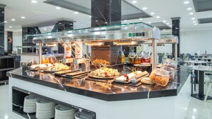 A buffet setup with various food items and a glass enclosure. - Pierre & Vacances Benidorm Horizon (Benidorm)