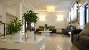 A modern living room with a glass coffee table, two sofas, and potted plants. - Green Garden Resort (Mestre)