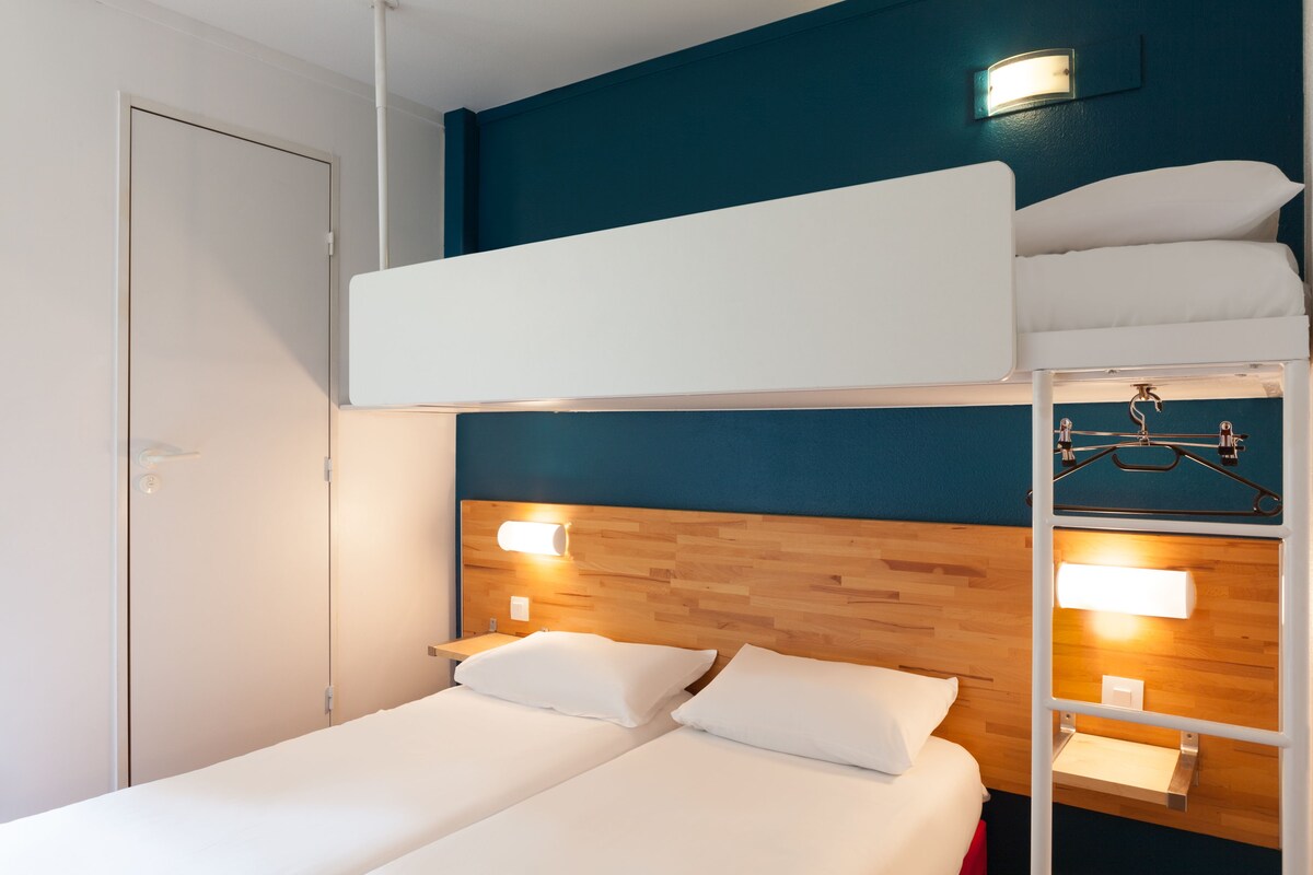 Una habitación con literas, una cama individual y un armario.