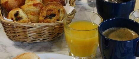 A breakfast tray with croissants, ham, cheese, and a cup of coffee.