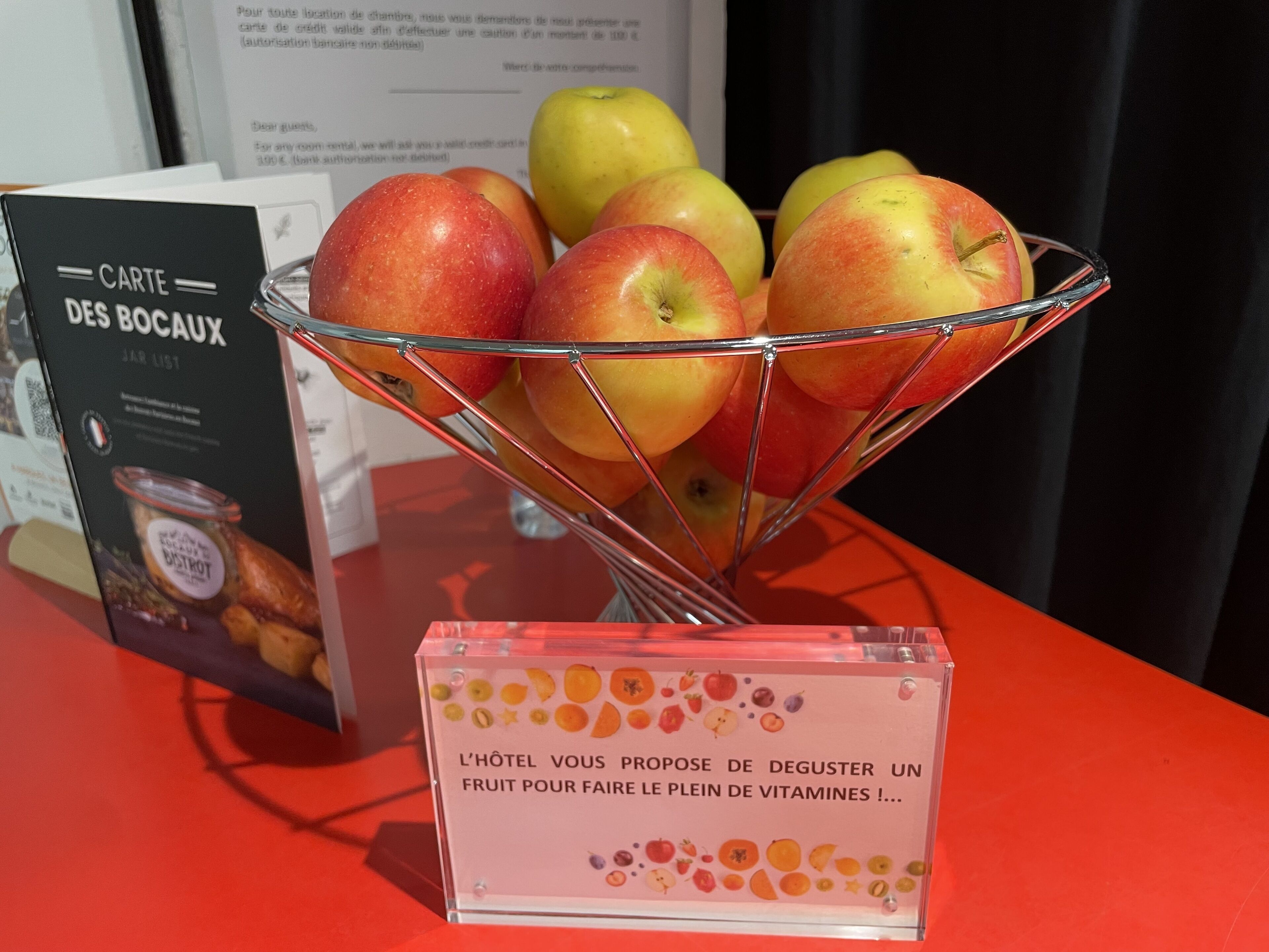 Presentació de fruita amb pomes i un cartell sobre el servei de fruita de l'hotel.
