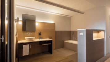 A modern bathroom with a large sink, mirror, and separate shower area.