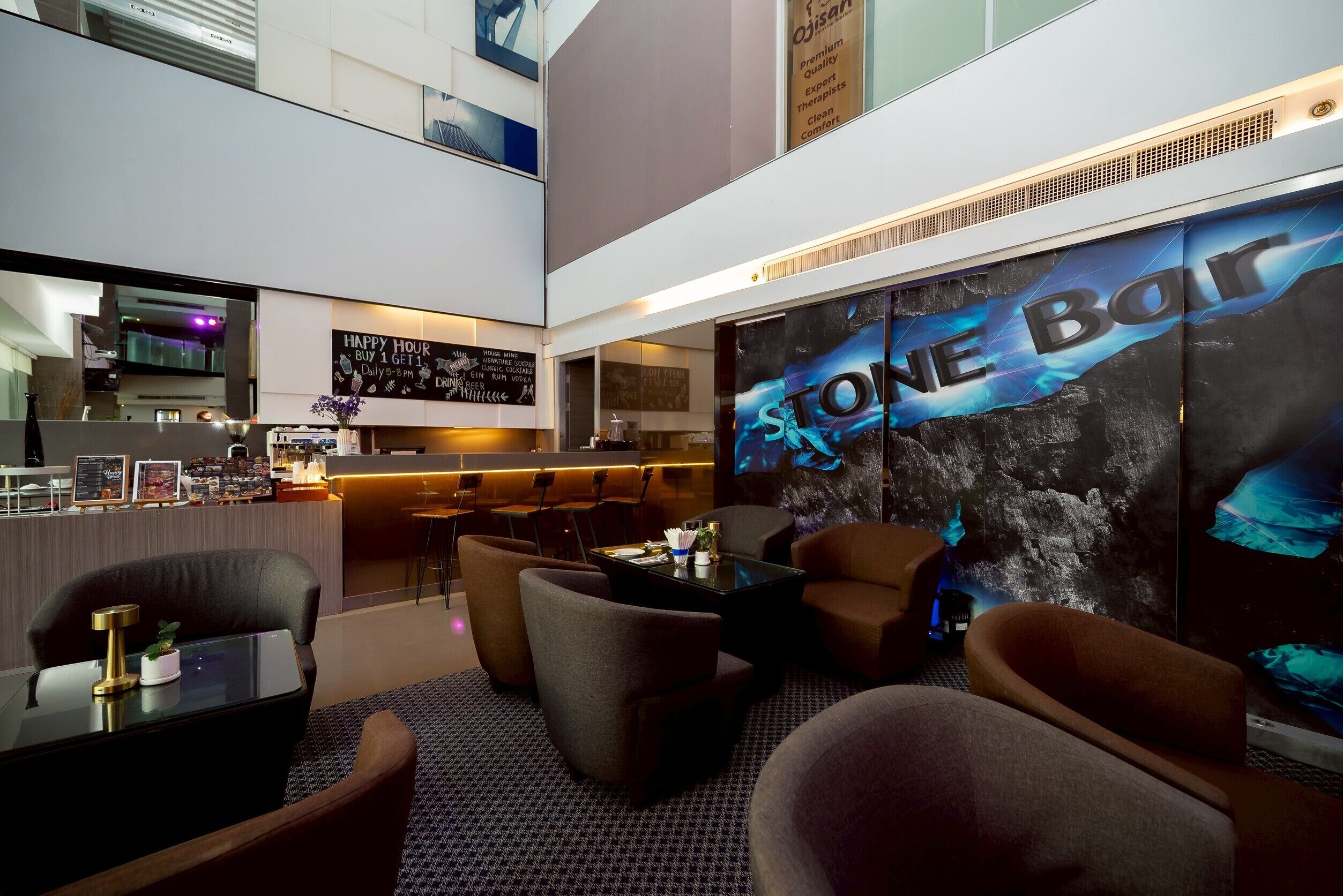 A modern hotel lobby with a bar area, seating, and a large wall mural.