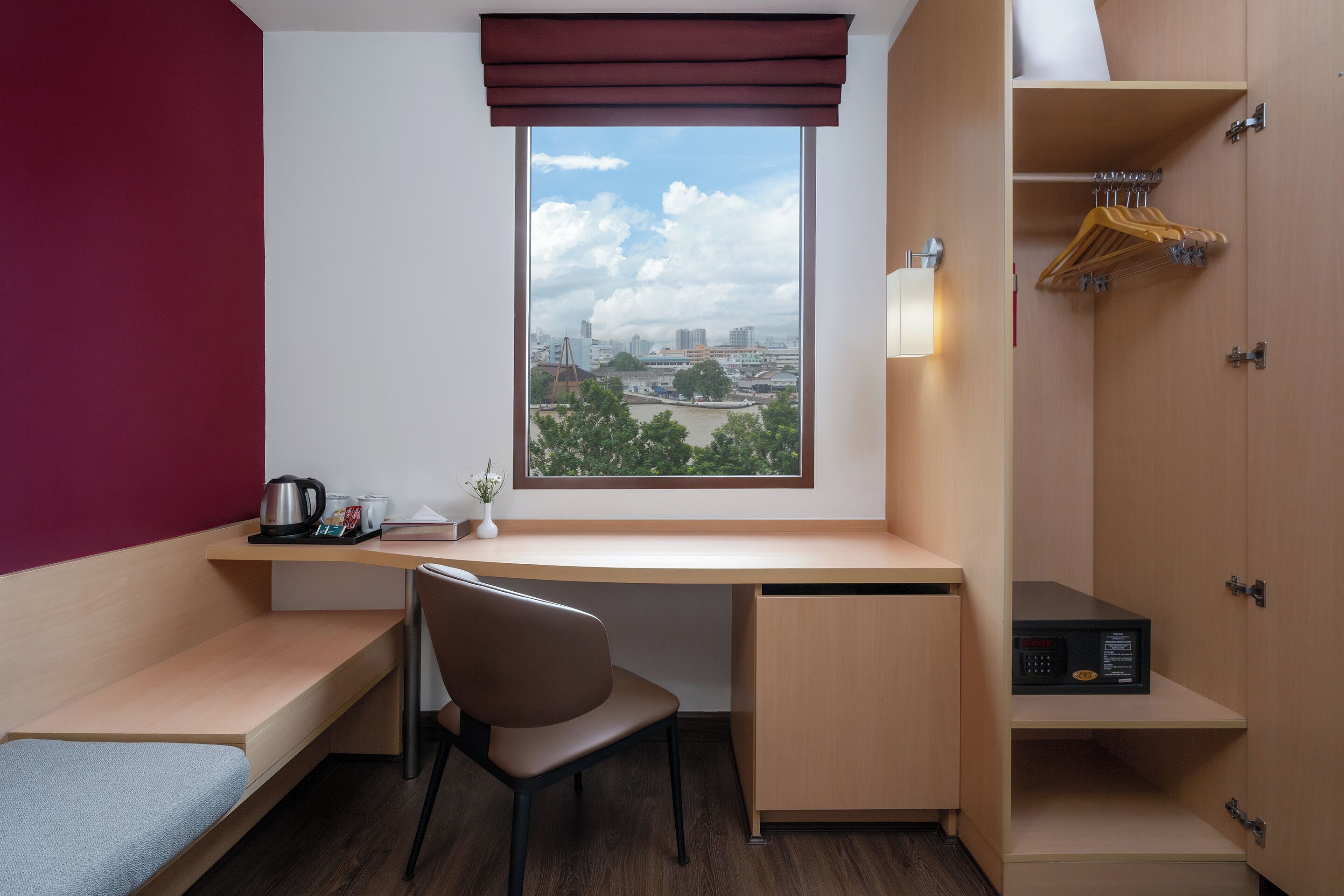 A modern room with a desk, chair, and a view of a cityscape through a window.