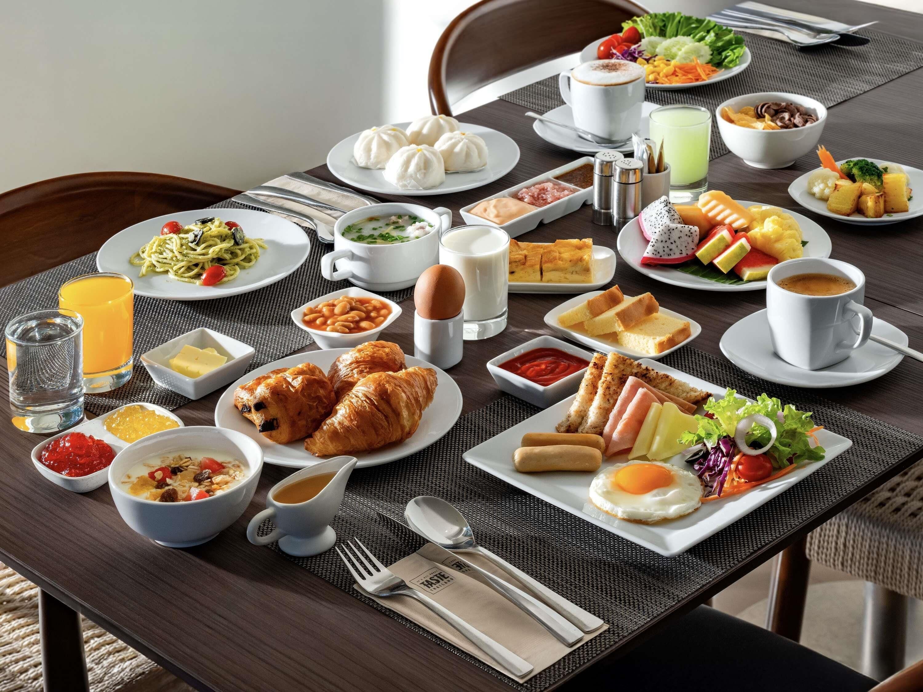 Un bufé de desayuno con diversos platos, como huevos, pasteles y ensaladas.