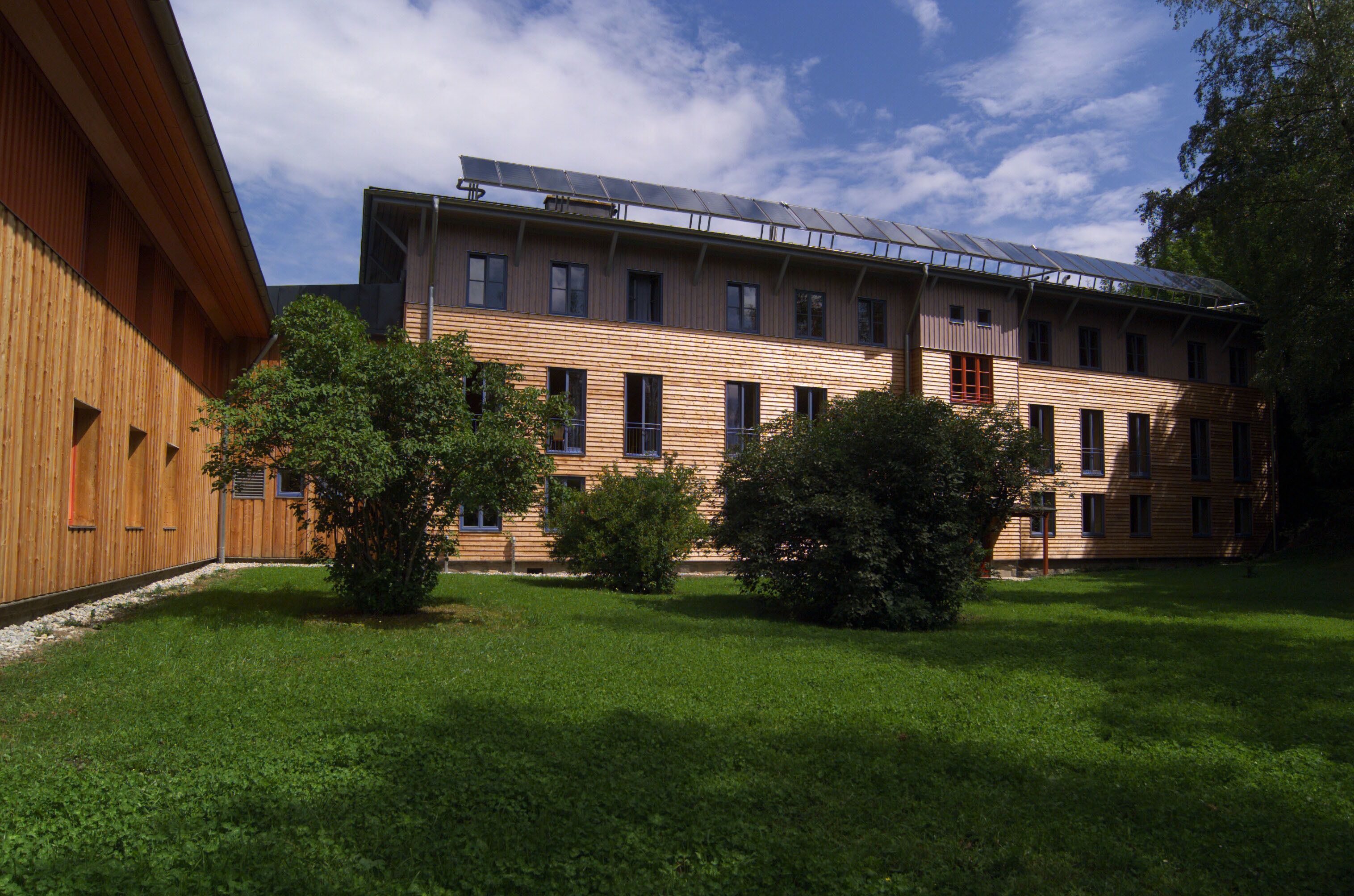 Un edificio moderno con techo plano y paneles solares.