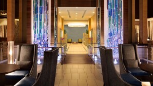 A hotel lobby with a central seating area, a reception desk, and a large chandelier. - Embassy Suites by Hilton Denver Downtown Convention Center (Denver)