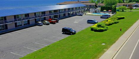 Un hotel con estacionamiento, piscina y vista al mar.