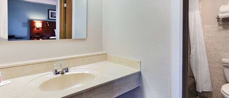 A bathroom with a sink, mirror, and toilet.