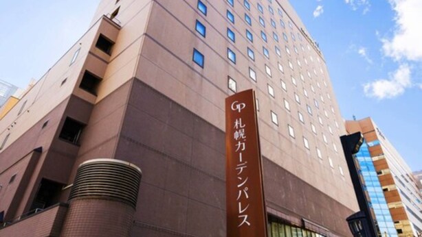Un edificio de hotel moderno y alto, con un letrero visible que indica que es el Hotel GP Marun Center.