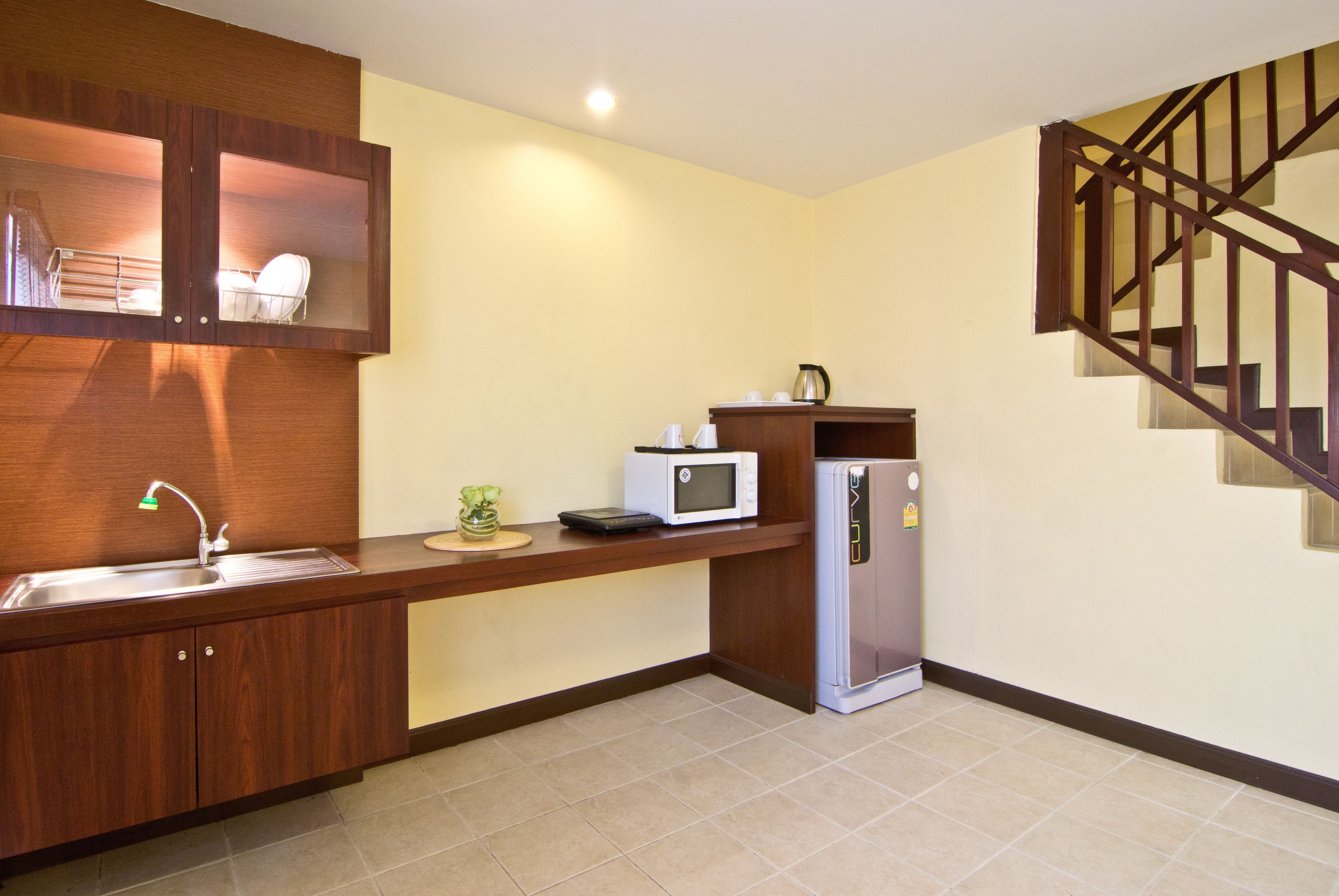 A compact kitchen with a built-in microwave, a refrigerator, and a sink.