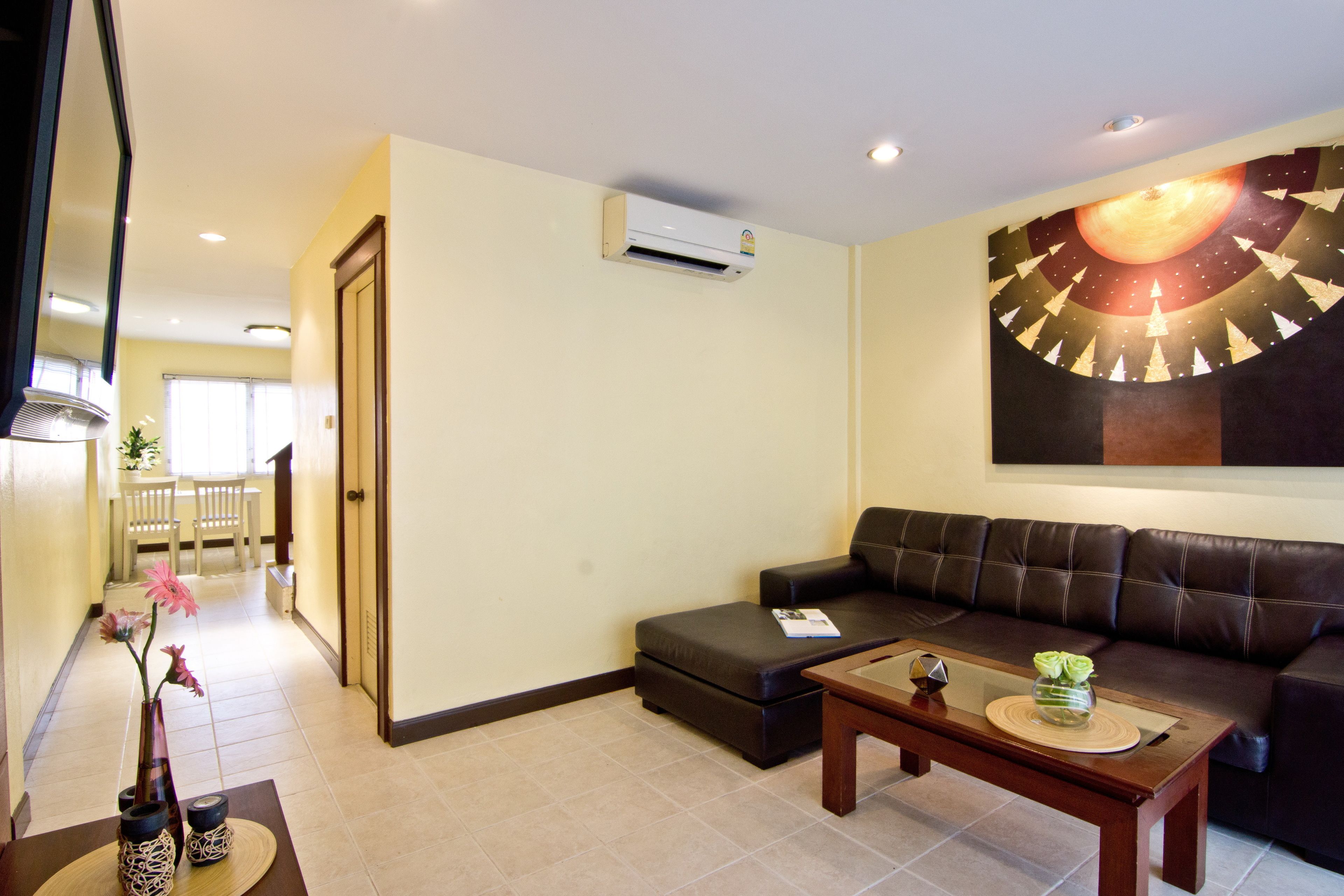 A living room with a sofa, a coffee table, and a painting on the wall.