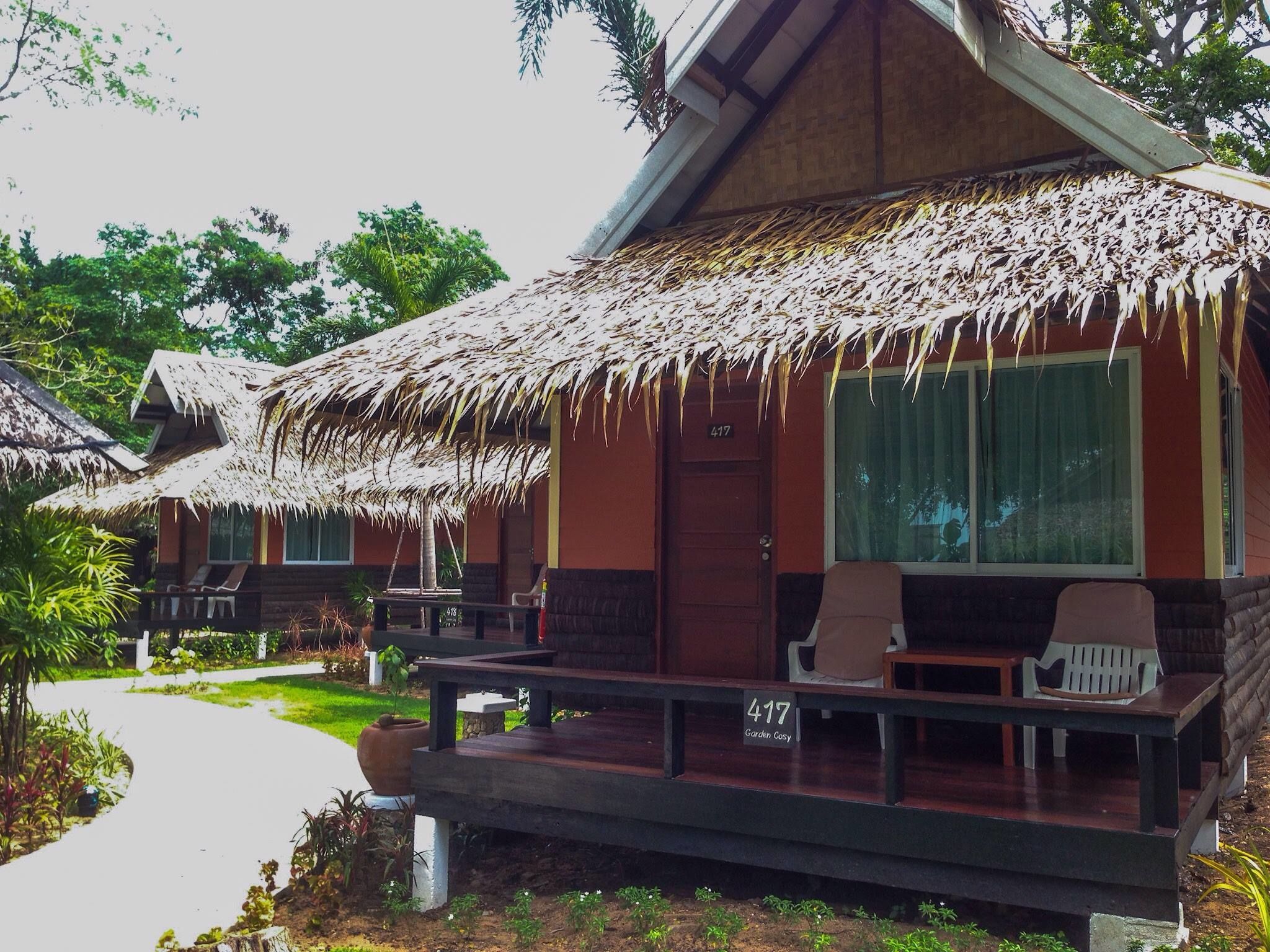 A bungalow with a thatched roof, a porch with seating, and a number '417' sign.