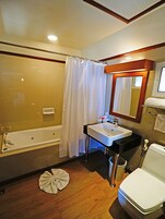 Un bagno con vasca, lavandino, WC e tenda per la doccia.