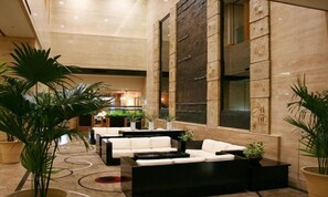 A spacious lobby with a modern design, featuring a large seating area with sofas and a coffee table, surrounded by potted plants. - Nagoya Garden Palace (Nagoya)