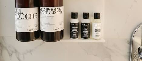 A bathroom shelf with various hair care products.