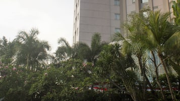 A high-rise building with a swimming pool and lounge chairs.