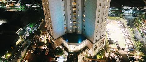 Un hotel de gran altura con varios pisos y una terraza en la azotea.