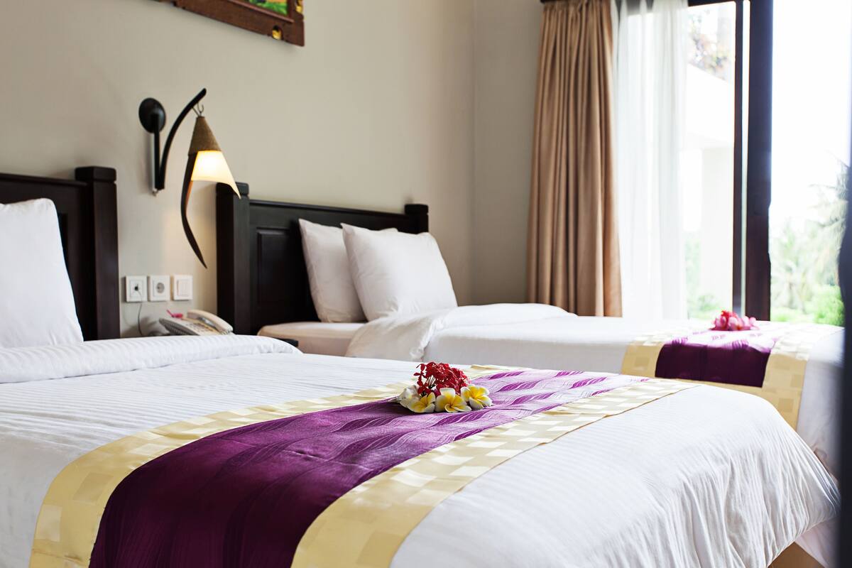 Ein Hotelzimmer mit zwei Betten, einem Telefon und einer Wandlampe.
