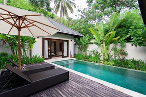 A private pool with a wooden deck, lounge chairs, and an umbrella. - Kebun Villas & Resort (Senggigi)