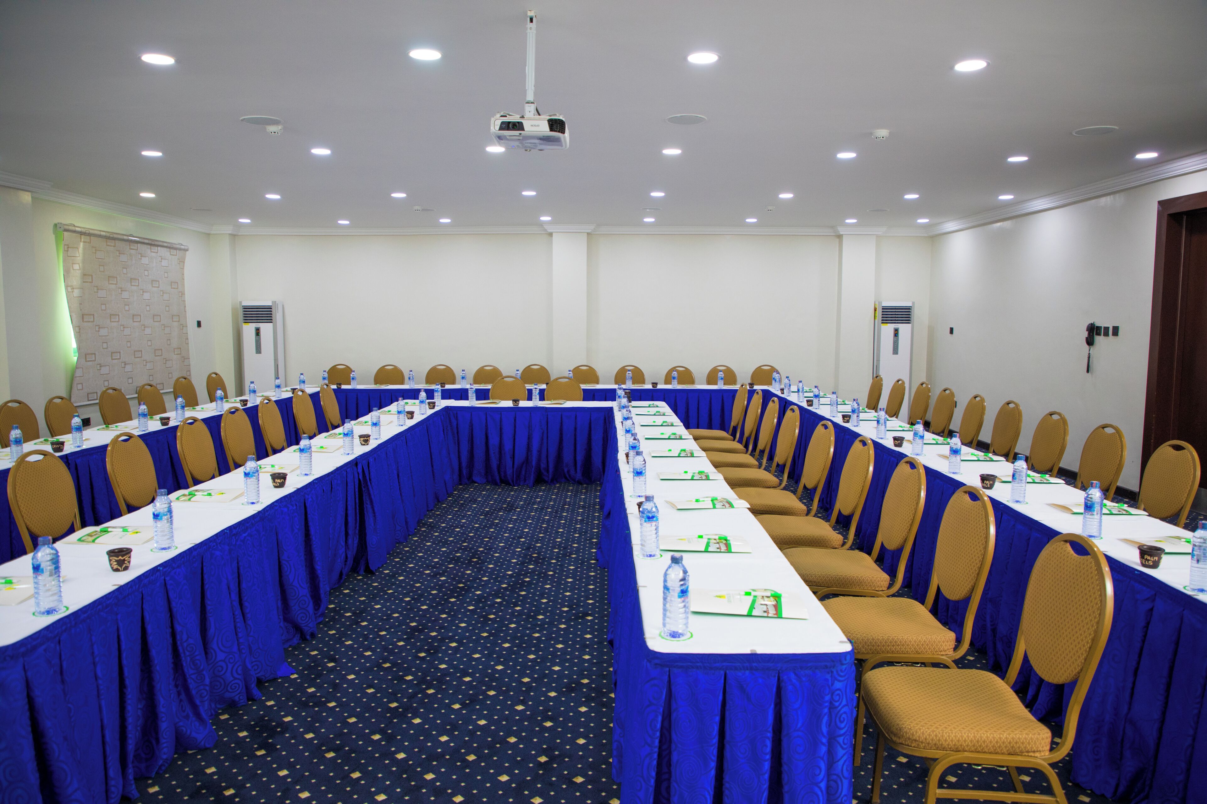 A conference room with a long table, chairs, and a projector.
