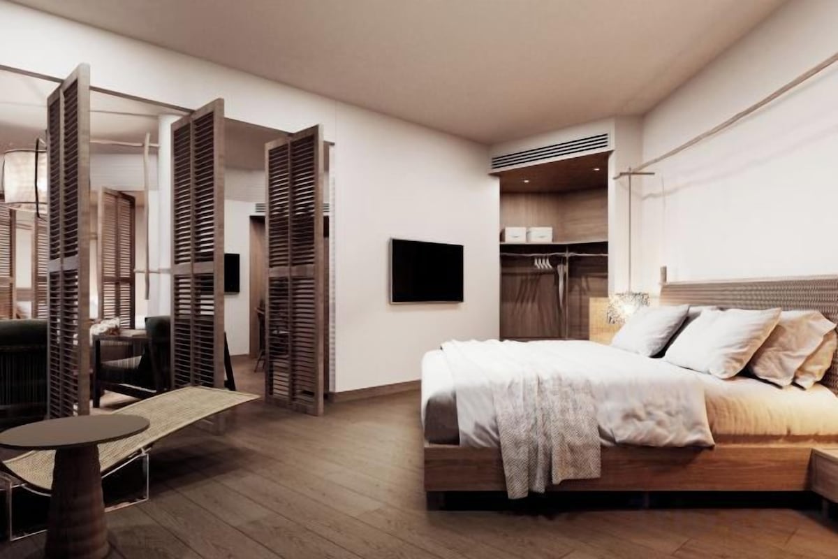 A modern bedroom with a bed, a desk, and a wardrobe.