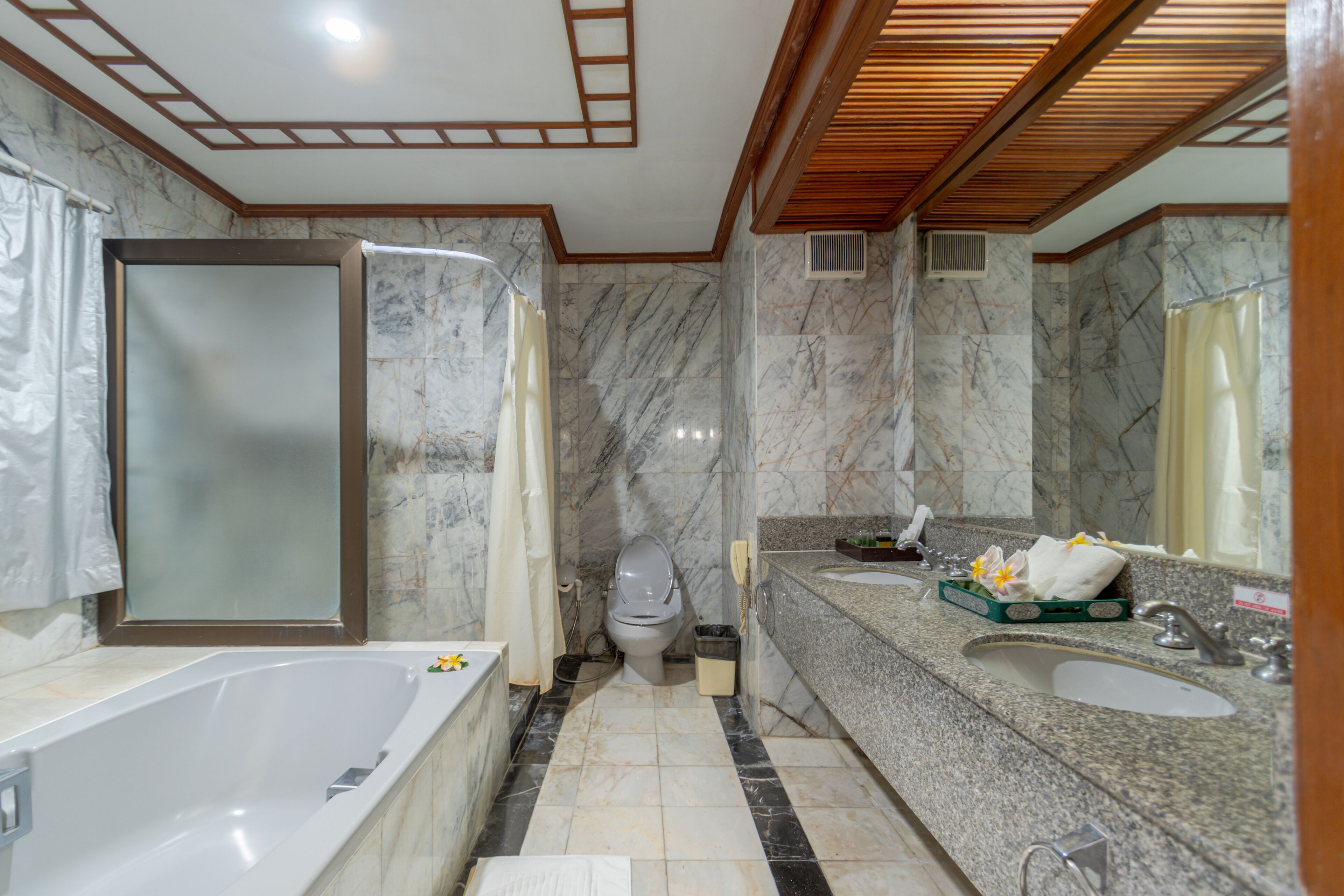 Un bagno moderno con vasca, servizi igienici e un mobile lavabo con lavandino e specchio.