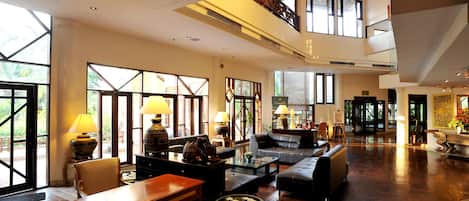A spacious lobby with high ceilings, large windows, and a modern interior design.