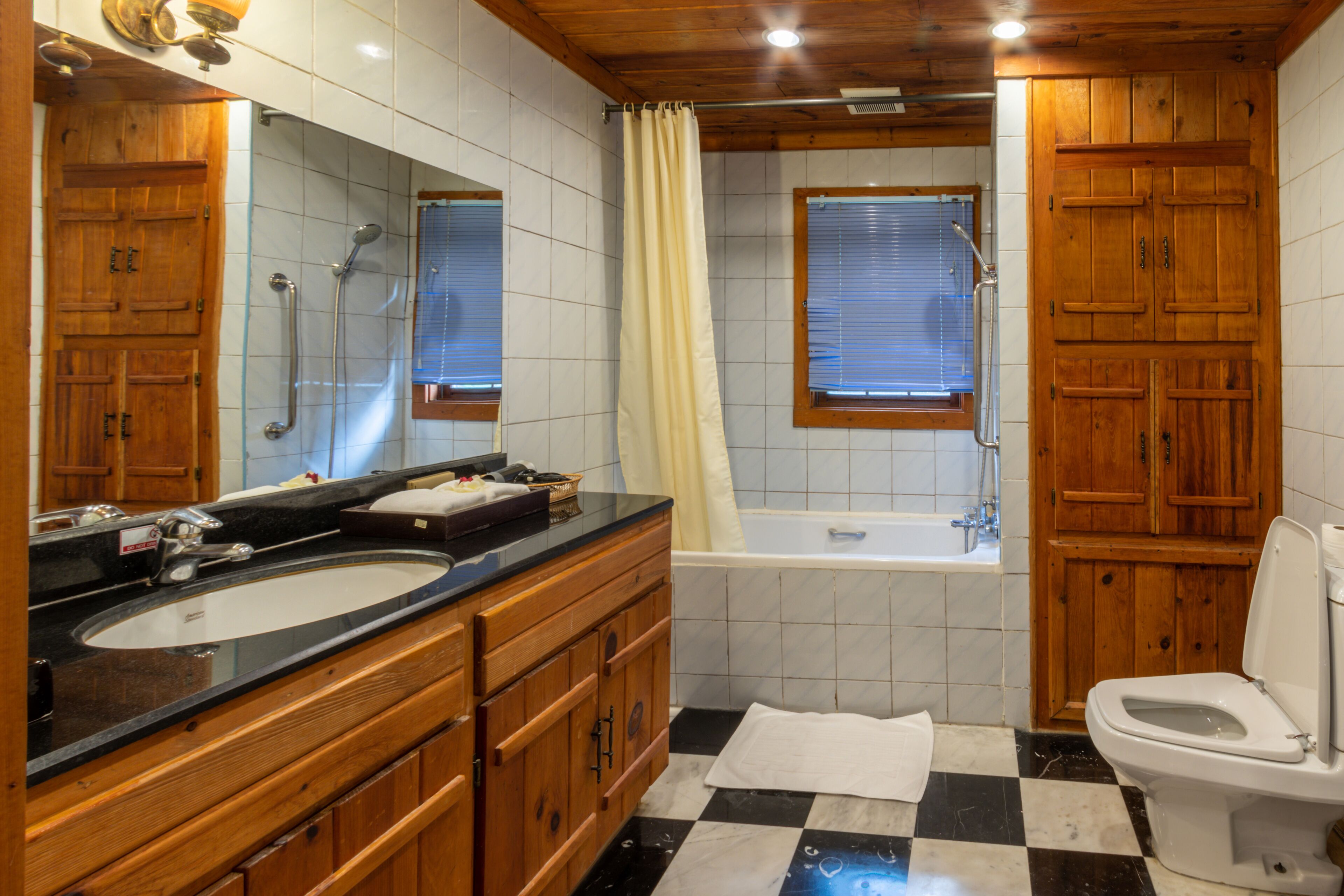 Un baño con dos lavamanos, una bañera y un inodoro.