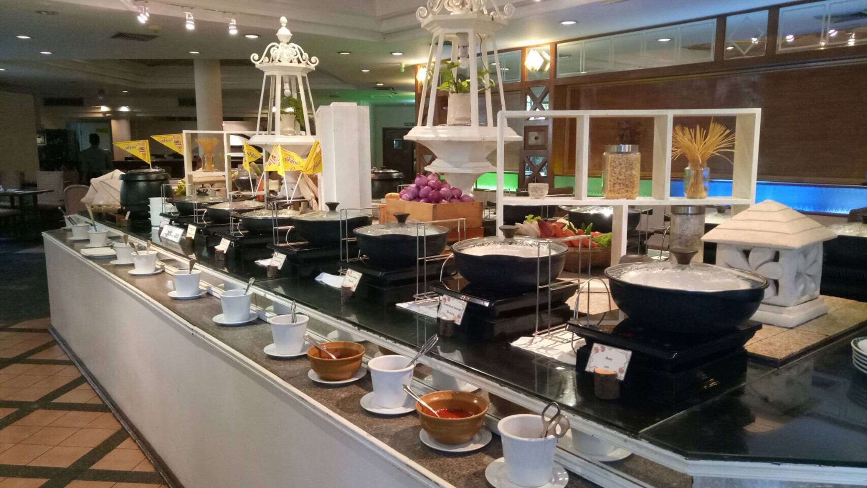 A buffet area with various food stations, including a hot pot and a salad bar.