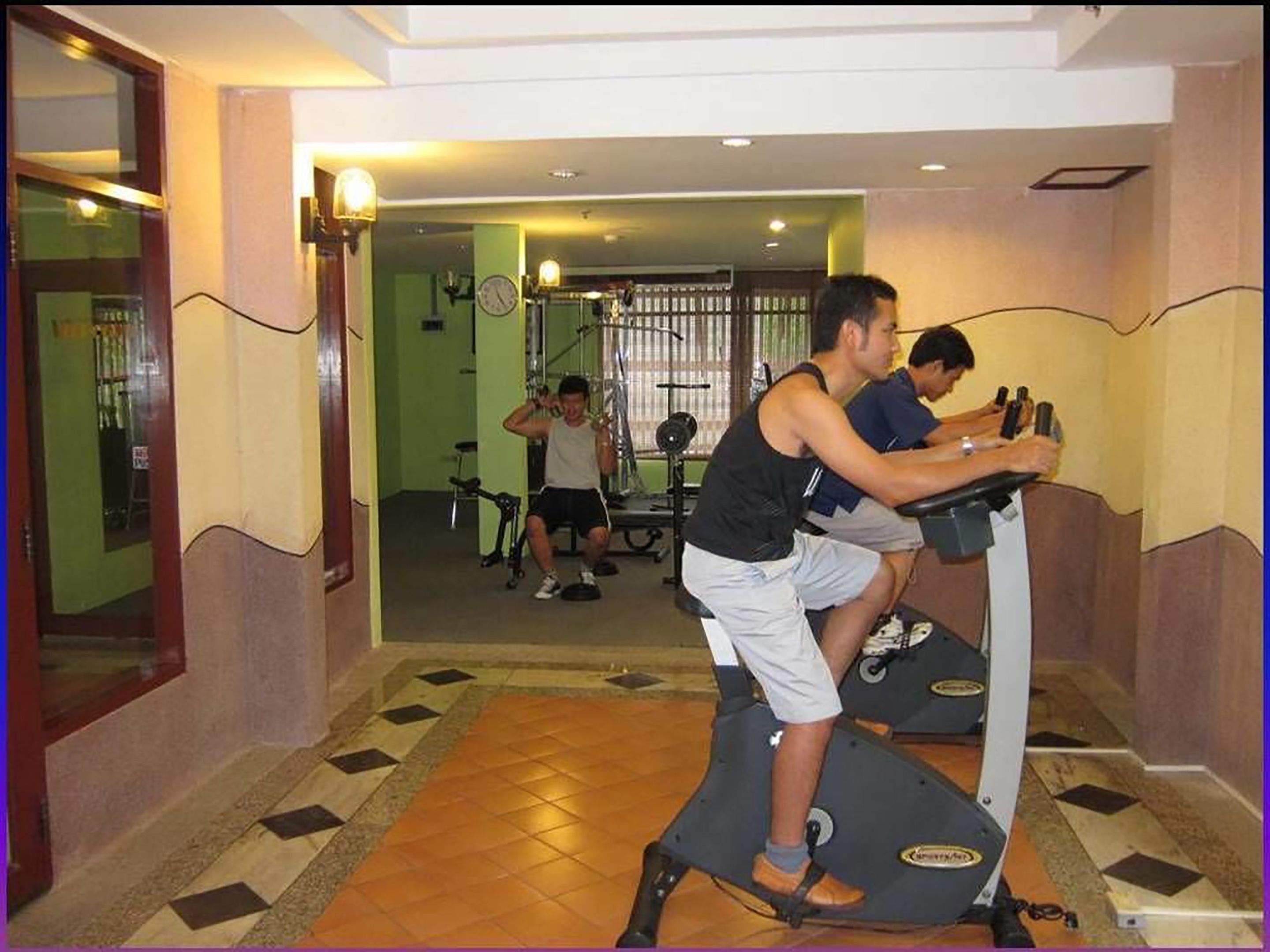 Un gimnasio con cintas de correr y equipamiento de ejercicio.