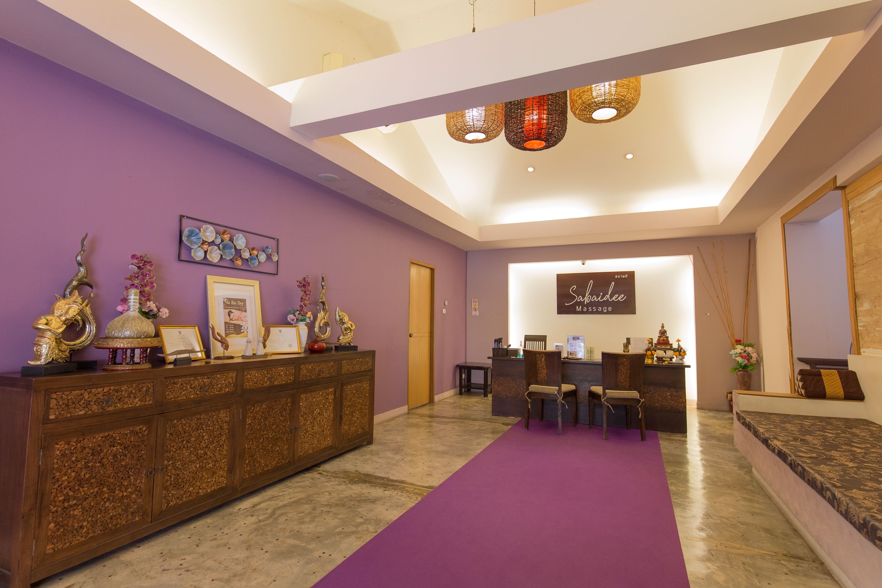 A reception area with a purple carpet, a reception desk, and a wall-mounted sign.
