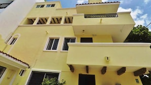 A multi-story building with a flat roof and a balcony.