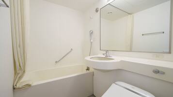 A bathroom with a bathtub, a sink, a toilet, and a mirror.