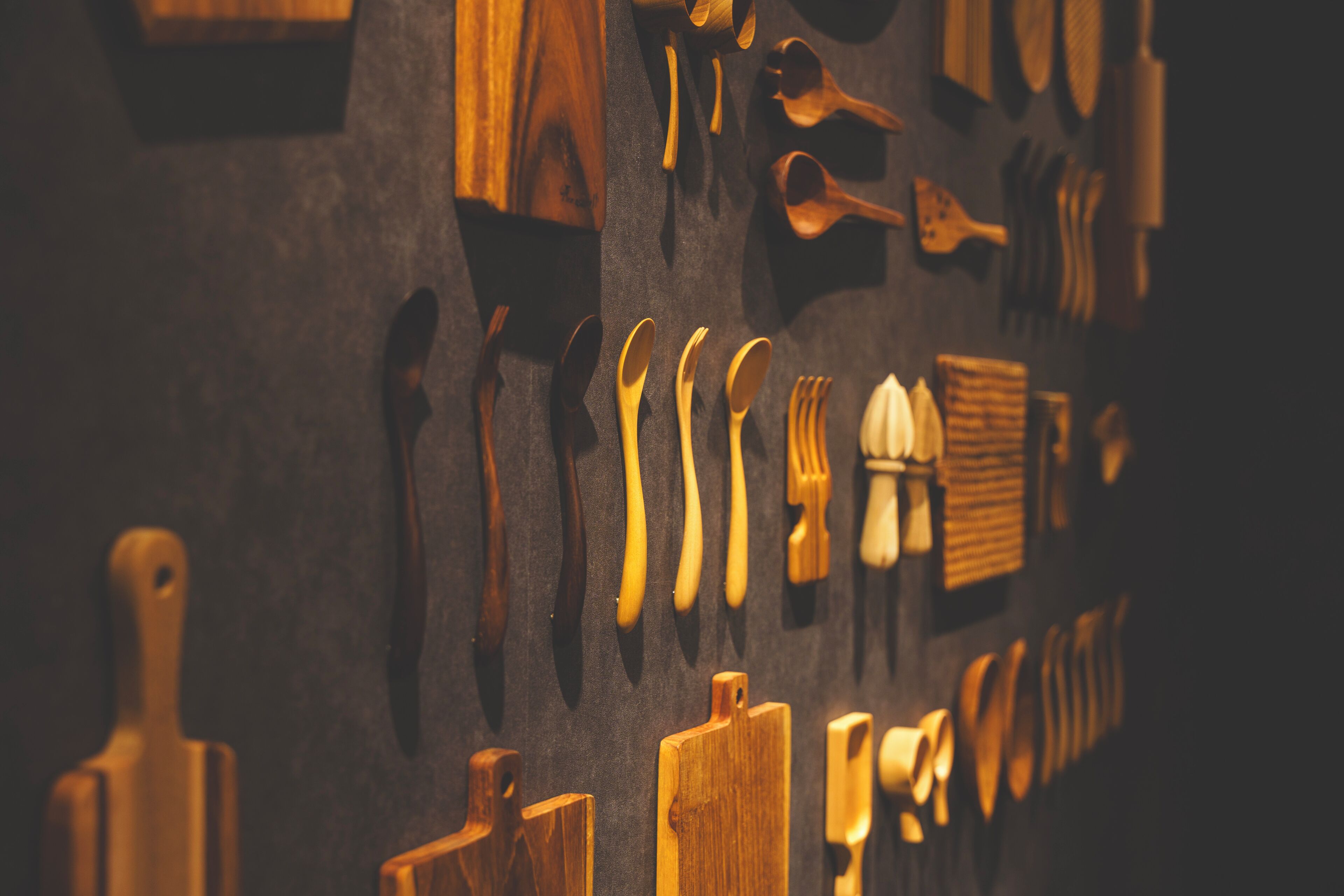 A wall with various wooden utensils and tools.